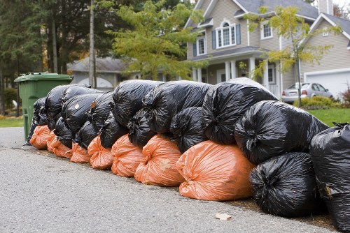Workers wearing PPE during skip loading and waste handling.